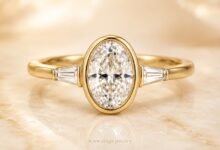 Oval bezel diamond engagement ring in yellow gold close up