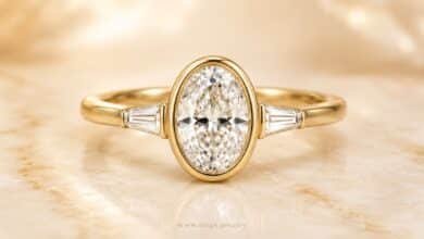 Oval bezel diamond engagement ring in yellow gold close up