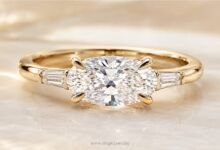 East-west oval diamond engagement ring close up on marble