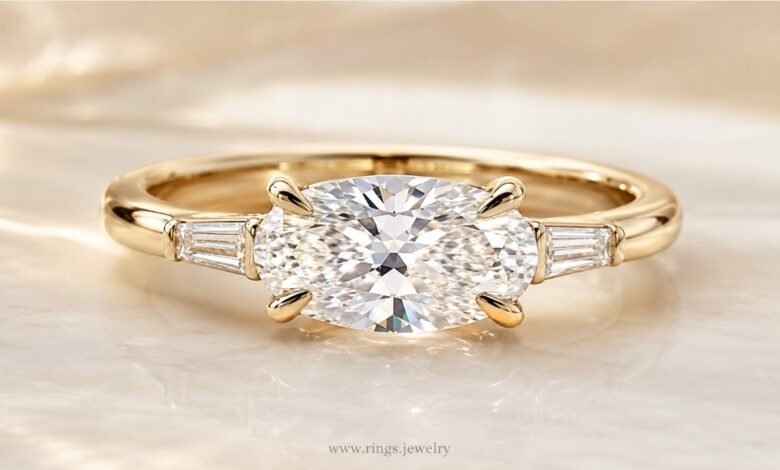 East-west oval diamond engagement ring close up on marble