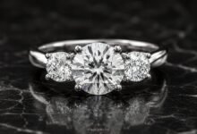 Three-stone diamond engagement ring close up on dark marble